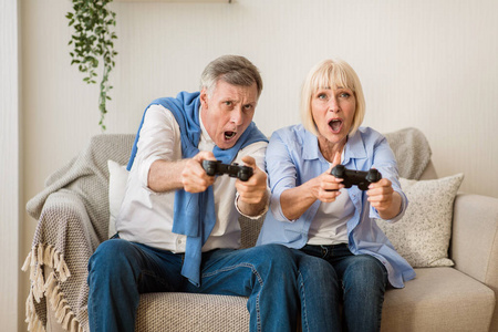 现代祖父母。喜欢玩电子游戏的老年夫妇
