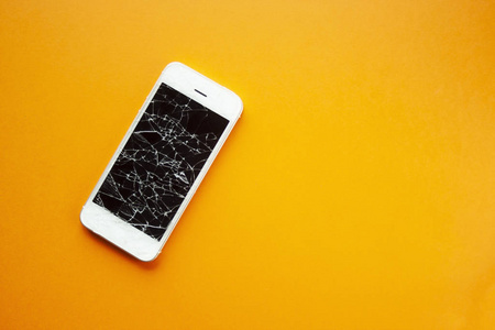 橙色背景的智能手机屏幕破裂