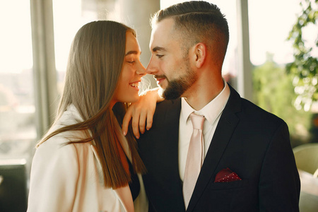 Elegant couple in a suits spend time in a cafe