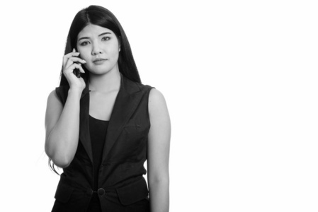 摄影棚拍摄的年轻亚洲女人在用手机说话