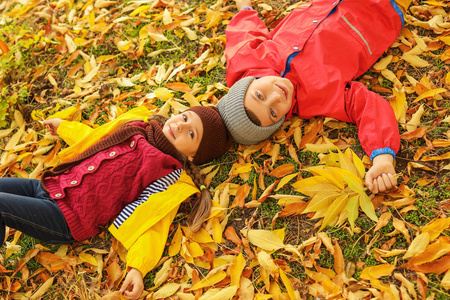 快乐的孩子们躺在秋天的公园里