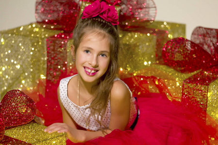 可爱的小女孩在发光的圣诞礼物盒里看着