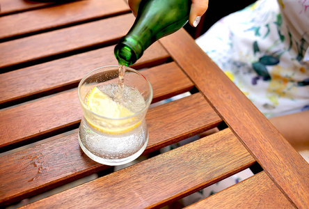  mineral water is poured into a glass on a table in a cafe