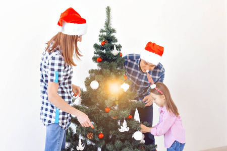 假日，圣诞节和庆祝概念幸福家庭装饰圣诞树在假日白色背景