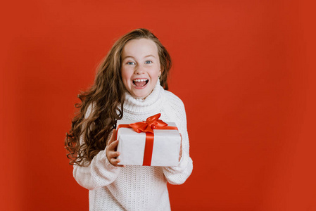 快乐兴奋的女孩拿着圣诞礼盒。