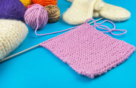 蓝色背景的针织套装。粉红色的餐巾，连指手套和围巾