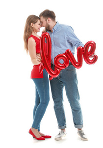 一对幸福的年轻夫妇，白色背景上画着爱字的气球。情人节庆祝