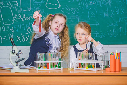 我们热爱科学。小学生在科学教室里做实验。小女孩科学家拿着试管在自然科学课上。学校与教育科学实验室