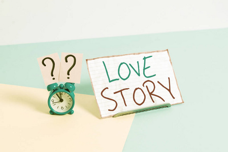 手写文字爱情故事。概念意味着它是一部小说或电影，讲述的是一个爱情故事的迷你闹钟，旁边是一张纸，放在柔和的背景上。