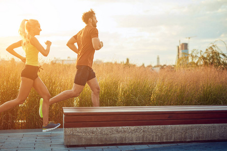 Modern woman and man jogging  exercising in urban surroundings 