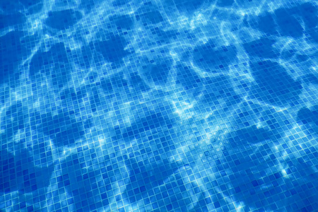 游泳池的水。潺潺流水。太阳反射背景。