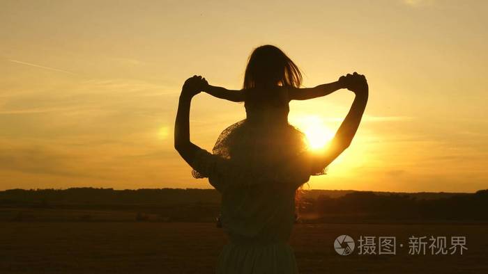 有孩子的年轻家庭.孩子们妈妈在阳光下的草地上玩耍.