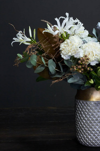 白色调花束复古风格在一个陶瓷花瓶在黑暗的背景，选择性聚焦