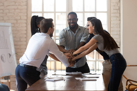 喜出望外的多民族年轻队友在办公室庆祝员工团结.照片