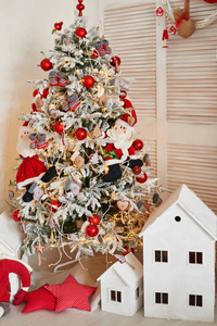 圣诞快乐斯堪的纳维亚或美国风格的房间内部有手工制作的小房子。带圣诞装饰的斯堪的纳维亚客厅。圣诞室内室。