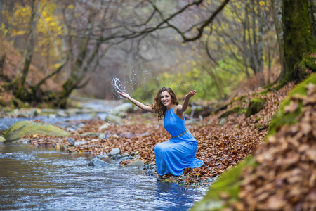 秋天，一个穿着蓝色衣服的女人在河边