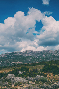 Mountains against a beautiful blue sky with fluffy clouds. 