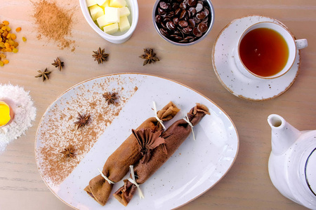 巧克力俄罗斯薄饼，布利尼和凝乳馅盘。提供一杯茶和巧克力。