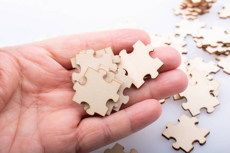 Hand holding piece of jigsaw puzzle as problem solution 