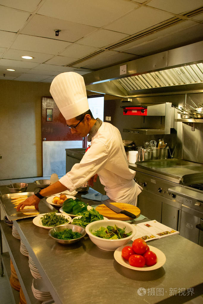 厨房里穿着制服的厨师正在准备布切塔和奇肯皮卡塔