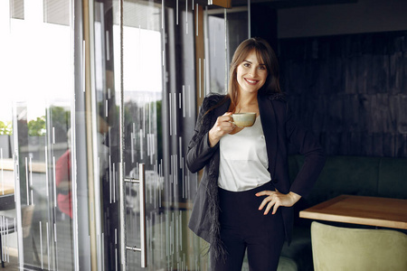 Elegant businesswoman working in a  and drinking a coffee