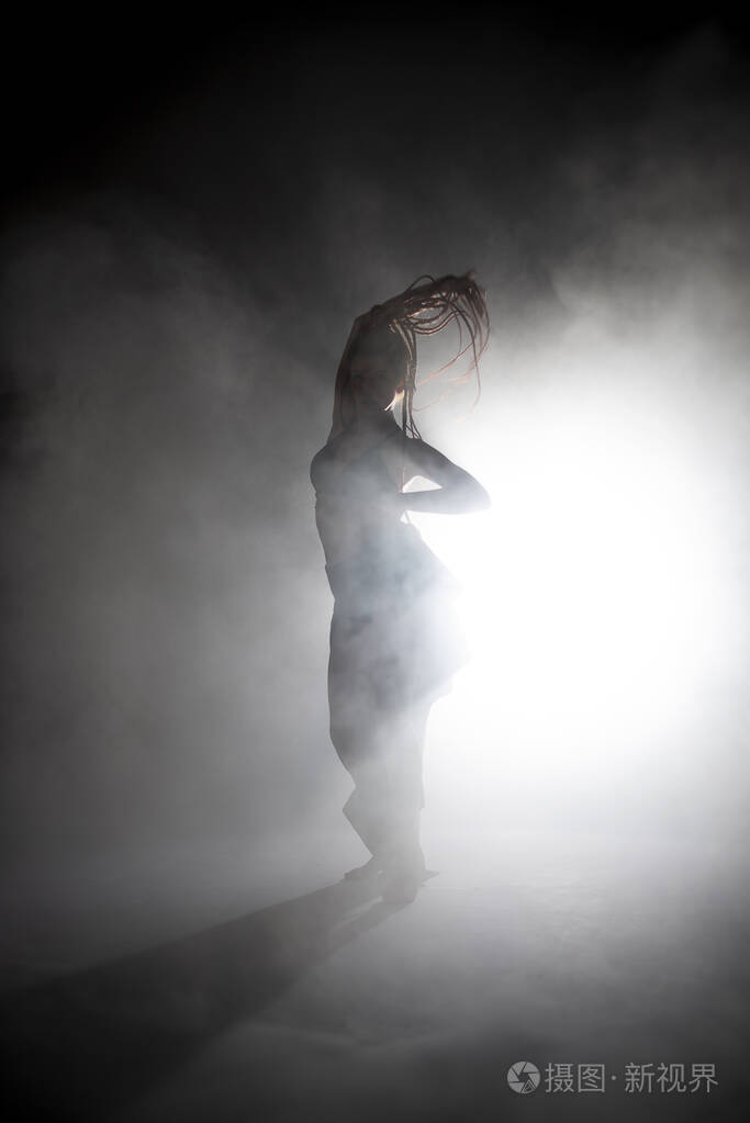 剪影舞女在雾中表演舞蹈人物