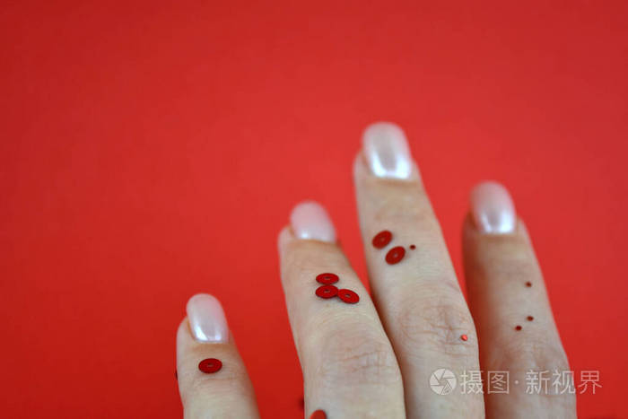 手上的红色闪闪发光.女性手孤立在红色背景和闪光.节日概念