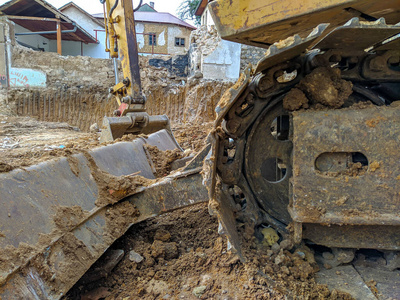 重型机械用挖掘机挖掘清理房屋建筑。现场工艺改造工作。