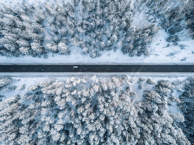 芬兰冬季道路和积雪森林鸟瞰图图片
