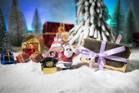 圣诞节和新年假期概念。小装饰可爱的小房子在冬天的夜晚，冷杉树站在雪地上，以美丽的节日装饰背景