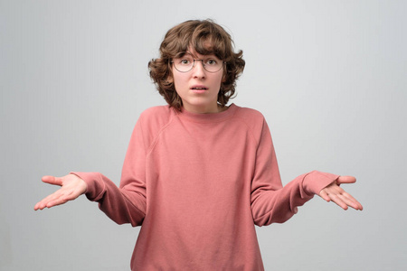 迷人的卷发女人耸耸肩.我不知道这是怎么发生的.照片