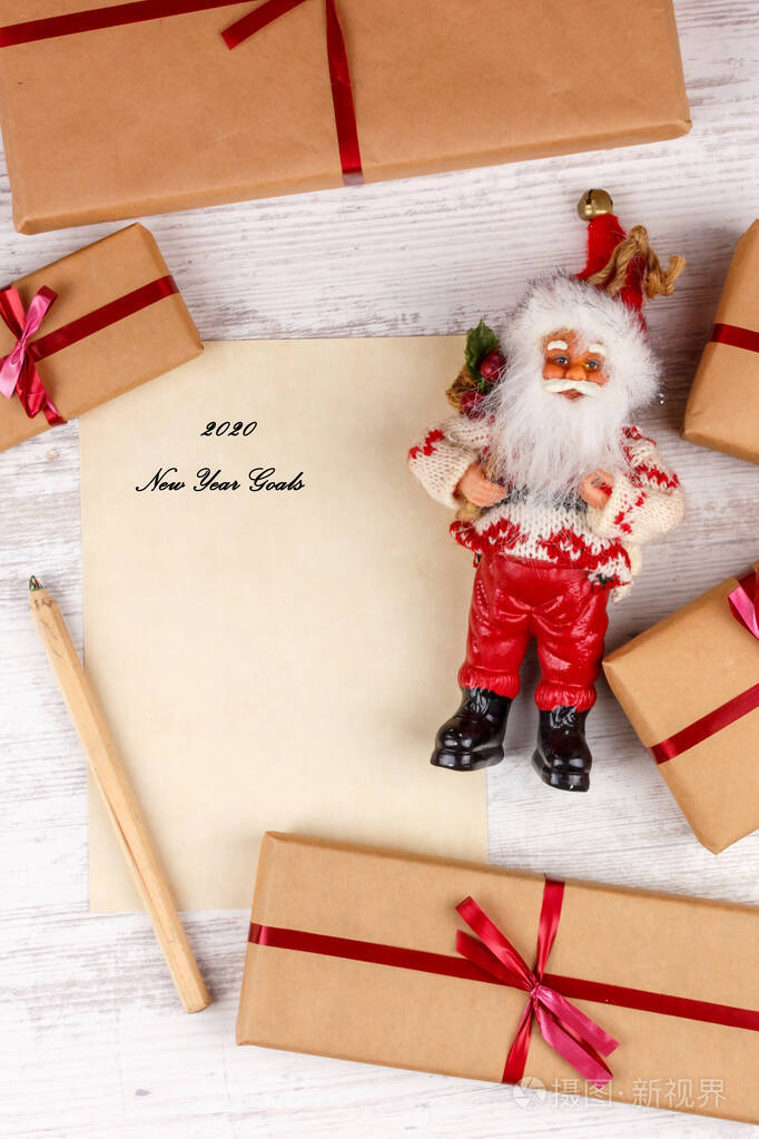 圣诞和新年背景与礼品盒，圣诞老人和一张写有新年目标的纸