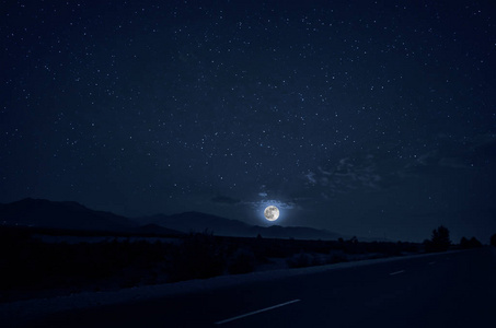 月圆之夜穿过森林的山路.夜景夜景,深蓝的天空和月亮.阿塞拜疆照片