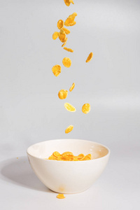 Corn flakes falling to the white bowl. Motion. 