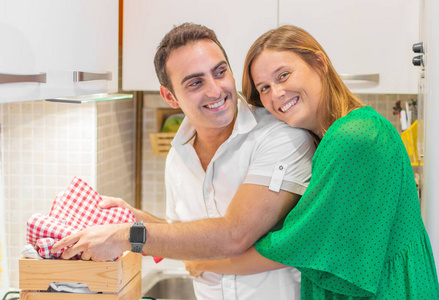 微笑的年轻夫妇在厨房做饭