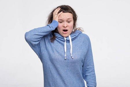 慌穿蓝衣服的女青少年慌了,记不得把手机放在哪里了.照片