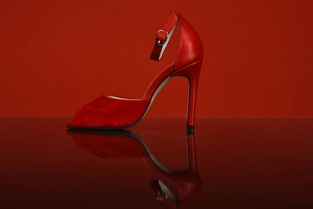 红色背景上的清漆制成的女式红色鞋子。漂亮的女鞋。高跟红色女鞋。女性时尚配饰。红色高跟女鞋。