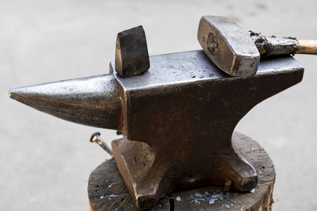 铁砧上的锤子和金属物体。铁匠在铁匠铺里使用的工具和金属物品。