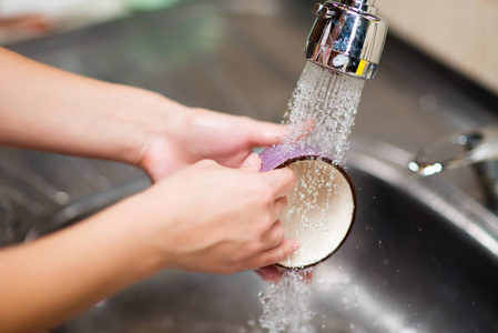 不戴防护手套的女孩洗杯子照片