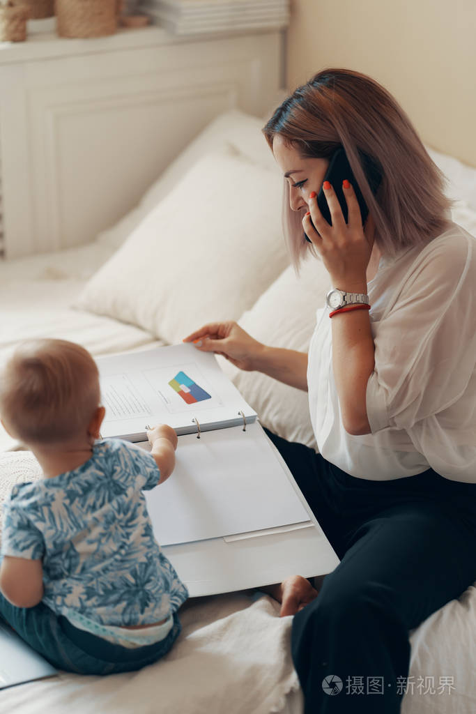 现代妇女带孩子工作多任务自由职业者和母亲的概念