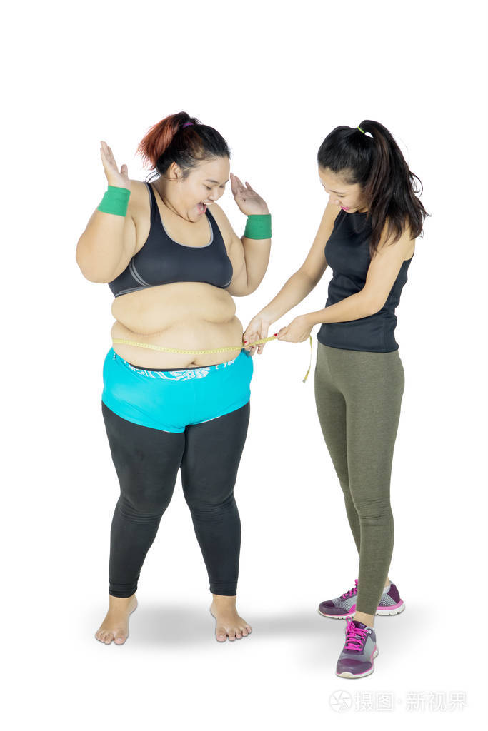 一个女人在测量另一个女人的胖肚子