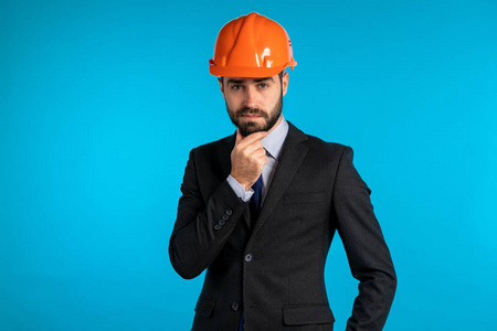 Pensive young engineer businessman in construction helmet. Man t