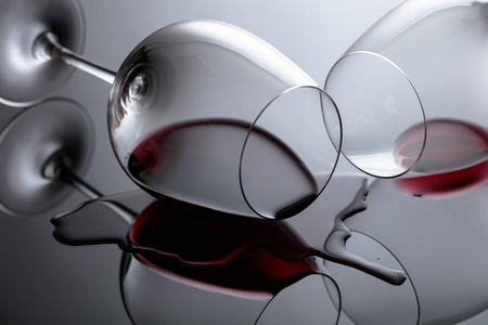 Glasses of red wine on a black reflective background. 