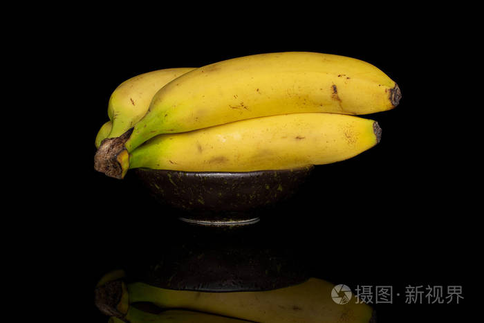 黑玻璃上隔离的甜黄色香蕉