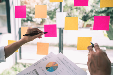 Business people meeting at  and use sticky notes on glass 