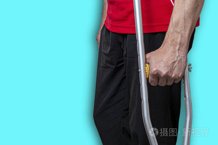 拄着拐杖的男人被隔离在蓝色背景下概念腿部注射