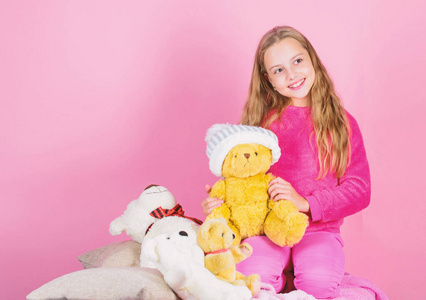 小孩小女孩玩软玩具泰迪熊粉红色背景。小孩小女孩顽皮地抱着泰迪熊毛绒玩具。熊玩具收藏。泰迪熊改善心理健康。柔软是关键