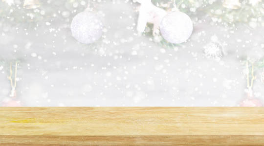 Empty wooden shelf over blur christmas tree background with snow