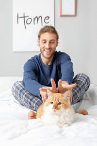 可爱有趣的猫和它的主人在卧室里照片