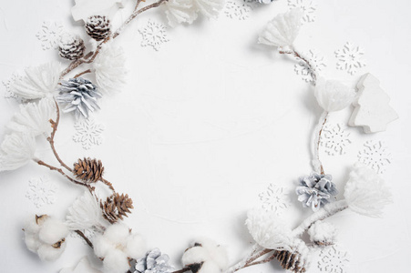 木制雪花棉花松果和白花球做成的圣诞花环。白色背景。平放，俯视图